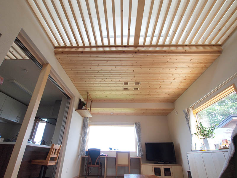 リビングの天井はパインの羽目板、壁は珪藻土を塗っている。ルーバー状になっている部分は、高窓からの光を室内に採り入れる役割もある