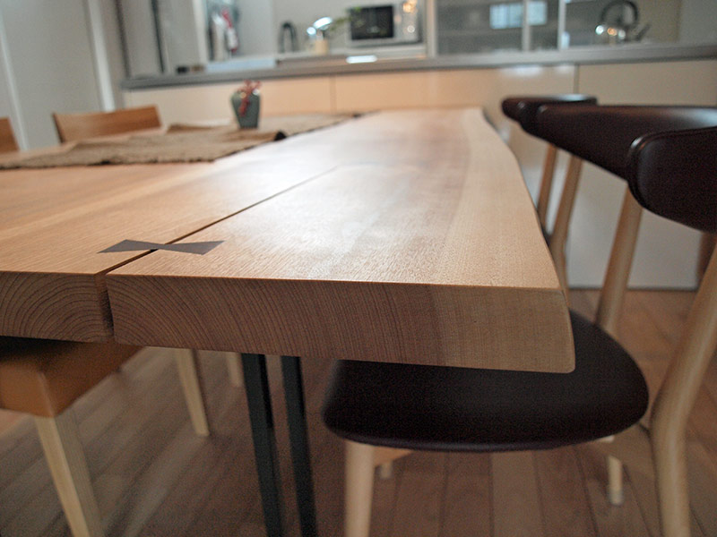 「澪工房」の一枚板のダイニングテーブルは、奥様の夢だった。澪工房は、その家具を「北海道モダン」と呼び、開拓に欠かせなかった「木・馬・斧」の象徴として「木・革・鉄」を組み合わせたデザインが持ち味