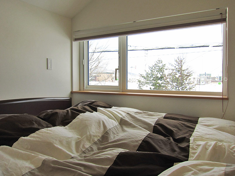 寝室には横長の窓をつけてワイドな眺望を実現。遠方には手稲の山々も見える