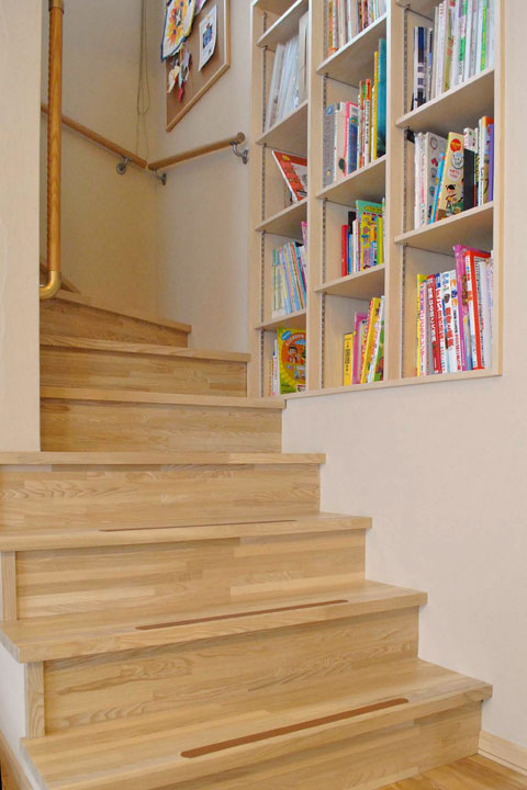 階段わきの壁にはニッチの本棚が。背丈ごとに各自のスペースが決まっており、お子さんたちはよく階段に座って本を読んでいるそう